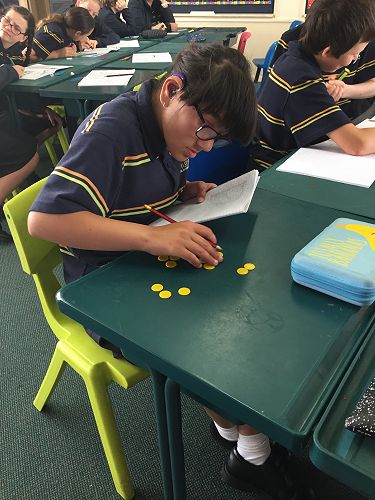 McKenzie working with counters to solve her equations.