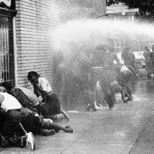 Citizens of Birmingham, Alabama are forced into submission by police with fire hoses, 1950s.