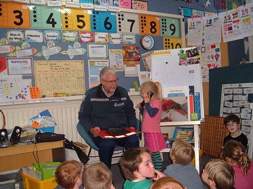 Constable Ross teaching Room 8 how to act in an emergency. 