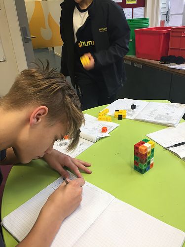 Izaak draws his rectangular prism into his workbook, then works out the volume.
