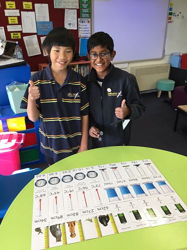 Ashton and Nimesh display the completed puzzles.