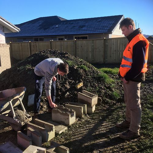 Zach White supervising Ruaidhri Brosnan doing some brick and block laying