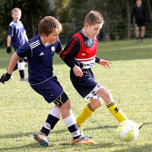 Saul Mawhinney works hard to block a cross in the Waihi Exchange Football Game.