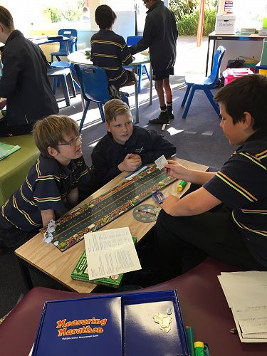 Kelvin and Aiden listen carefully as Rowan reads out a measurement question.
