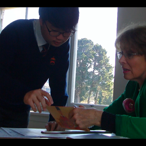 The examiner Pauline Douglas talking to Mingyu Jeong about his speech.