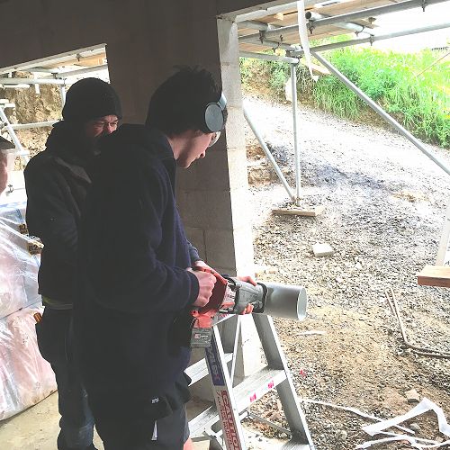 Zack Matthews cuts a pipe to size on his plumbing placement for Gateway