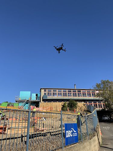 The drone doing a fly over while the concrete is being poured