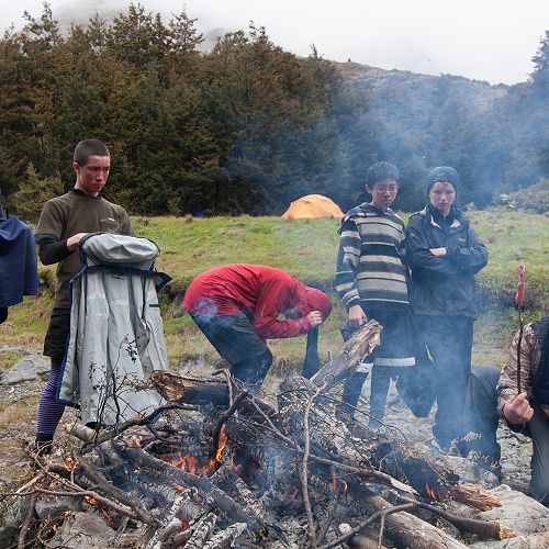 Barry Timmings, Josh Stoddard, Ben Wishart (crouching), Boen Deng, Lachlan Kenneally, and Jin Kim enjoy the fire after a day in the snow. &nbsp;