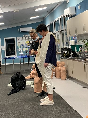 Mrs Fitzgerald being reminded on how to construct a sling