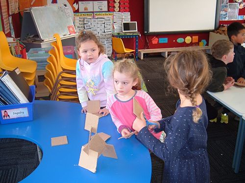 Sami, Rosie and Simone work together to make a cardboard tower using nothing but slits.