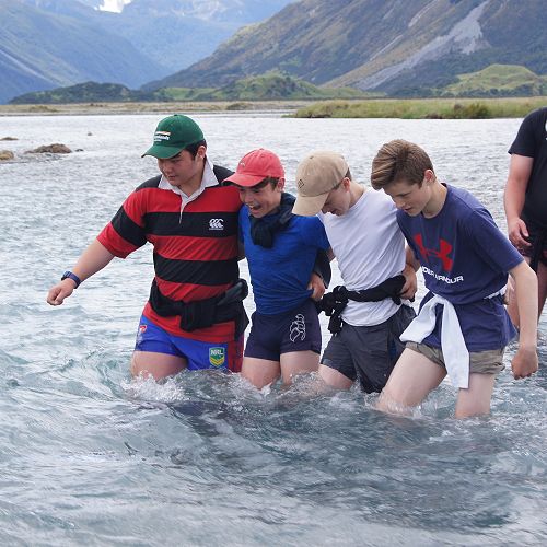 Robert, Tom, Aidan and Macauley practise river crossing in swifter water
