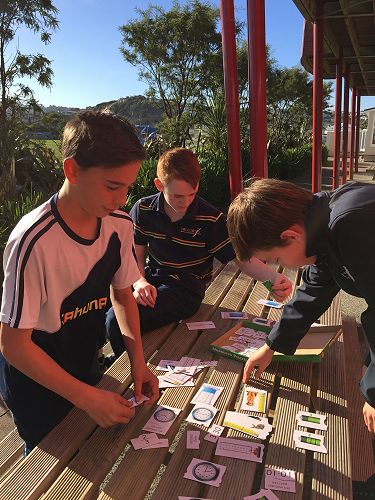 Frankie, Jackson and Leo working outside on their puzzles for maths.