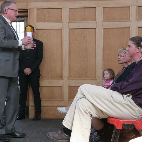 Rev Barry Kelk gives the family a memorial candle. &nbsp;