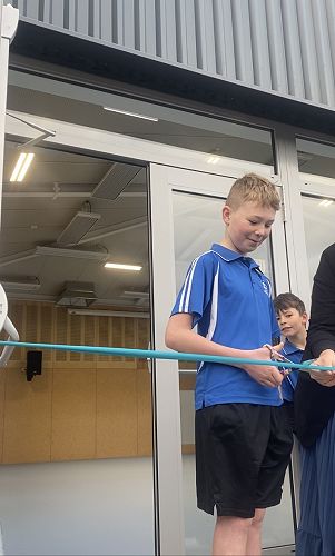 Hugh, the oldest pupil at Kaikorai cuts the other ribbon