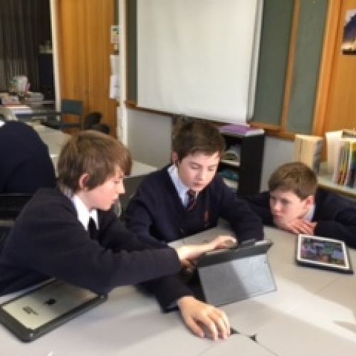 Y9 students work collaboratively using an iPad to create a joint presentation related to genetic modification.