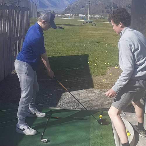 Matthew Hanna working with Connor Howes at the Frankton Driving Range.