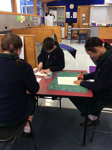 Using the craft knives to create our cardboard stencils.