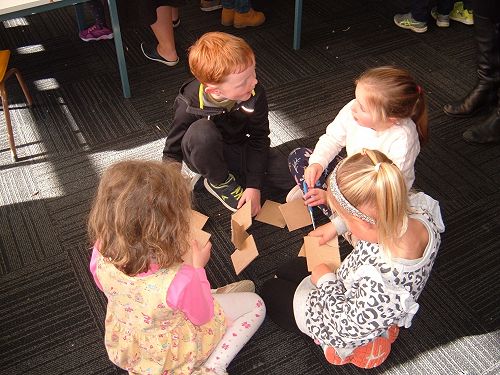 Learning to work in groups and to take turns making and creating with cardboard.