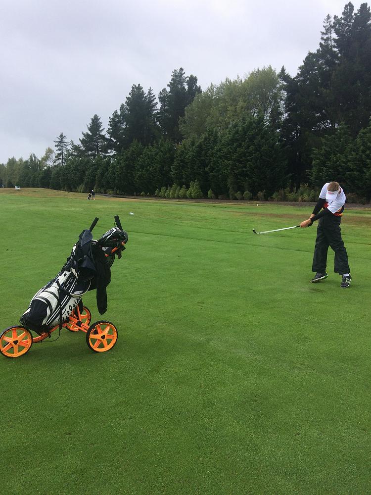 Callum White plays a drive on a sodden Clearwater fairway