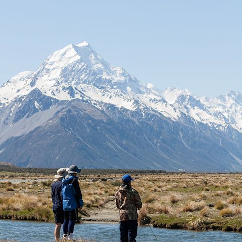 Jin Kim fishes for the elusive Monster trout with Aoraki Mt Cook in the background (and a group of supporters).